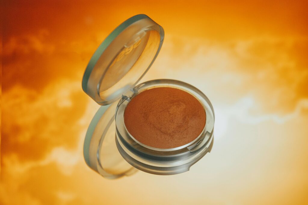  Best Bronzers illuminating a vibrant orange backdrop, ideal for makeup visuals.